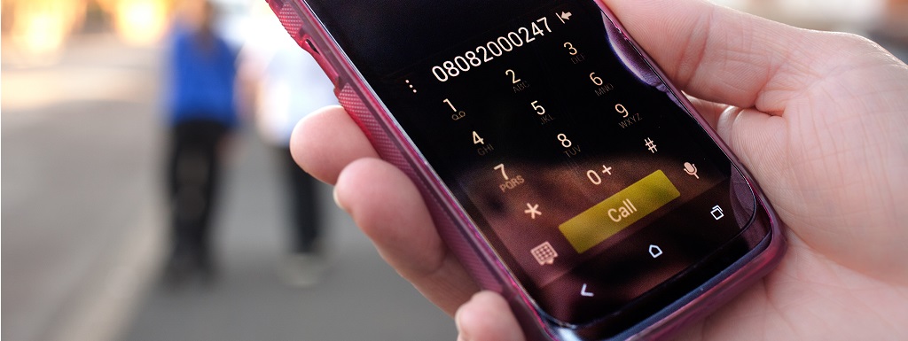 A telephone dialing domestic violence helpline number