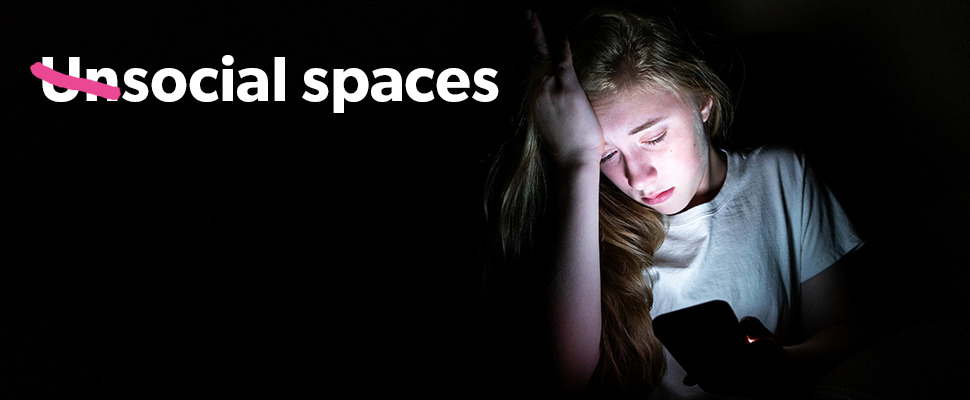 Text reads 'Unsocial spaces' with 'un' crossed through, next to photo of young woman looking worried on her phone in the dark.