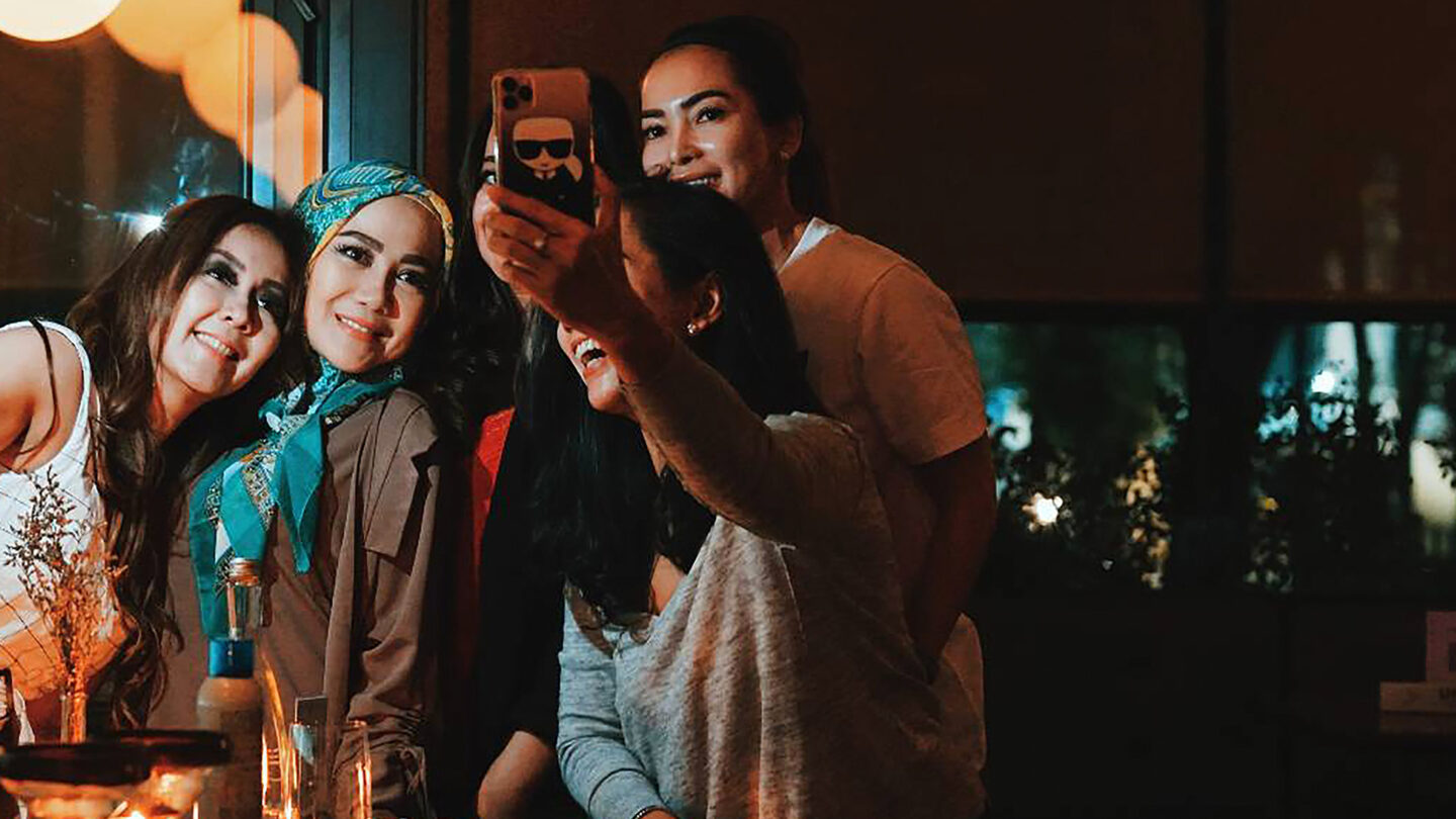 Group of women take a selfie at night
